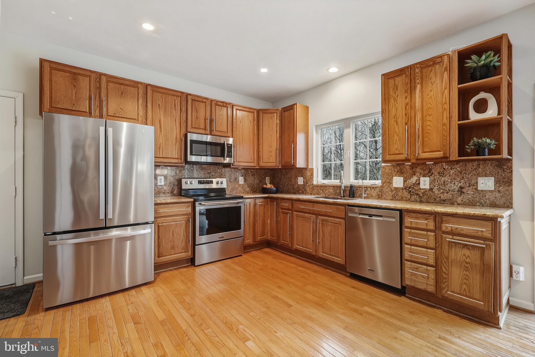 8439 Den Circle King George, VA 22485 - Photo 8 of 53 a kitchen with granite countertop stainless steel appliances a refrigerator cabinets and wooden floor