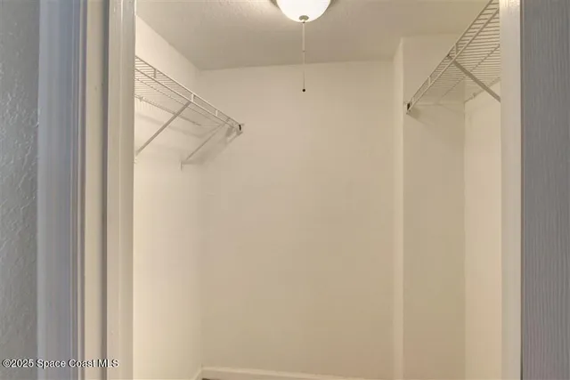 a view of a big building with a big yard plants and large trees