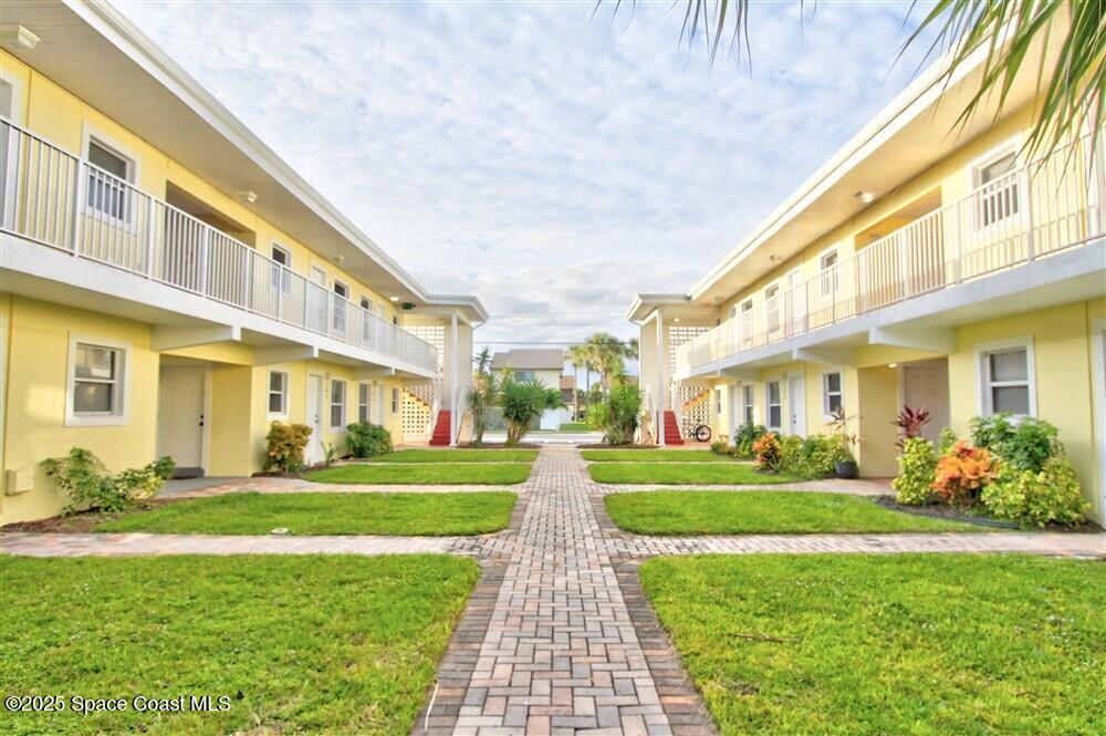 130 Roosevelt Avenue, Unit 104 Satellite Beach, FL 32937 - Photo 20 of 21 a view of a big building with a big yard plants and large trees