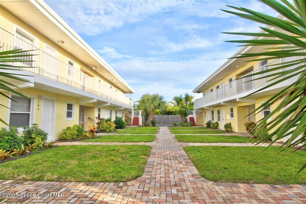 130 Roosevelt Avenue, Unit 104 Satellite Beach, FL 32937 - Photo 21 of 21 a front view of a building with a garden