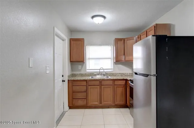 a kitchen with stainless steel appliances granite countertop a refrigerator and a sink
