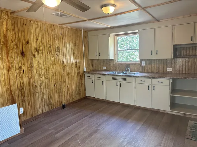 a kitchen with a sink a window and cabinets