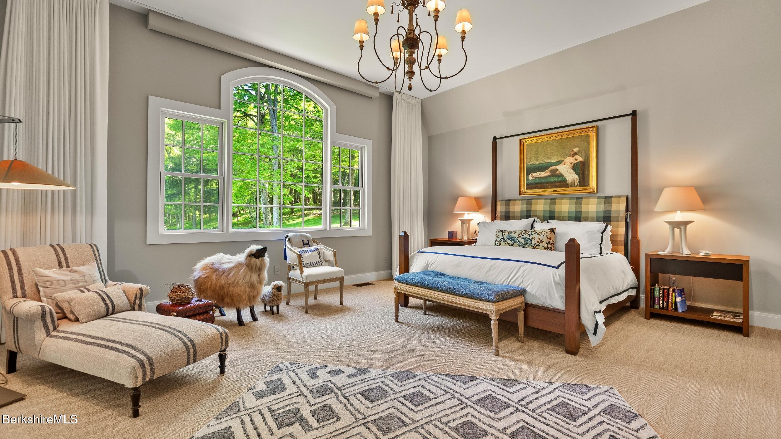 232 Giberson Road Sheffield, MA 01257 - Photo 12 of 53 a bedroom with a bed a chandelier and a window