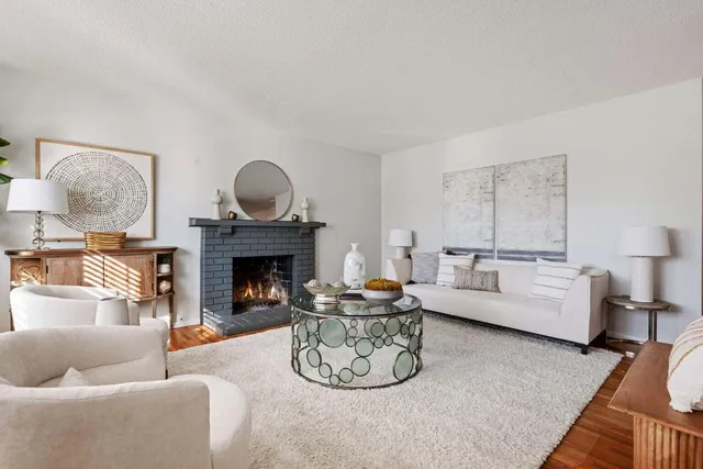 a living room with furniture a fireplace and a table