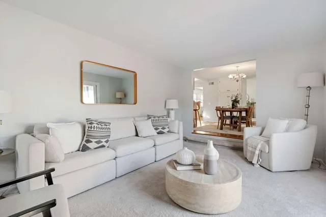 a living room with couches and a potted plant on table