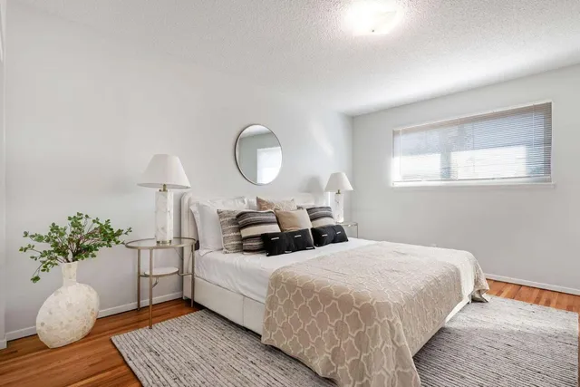 a bedroom with bed and wooden floor