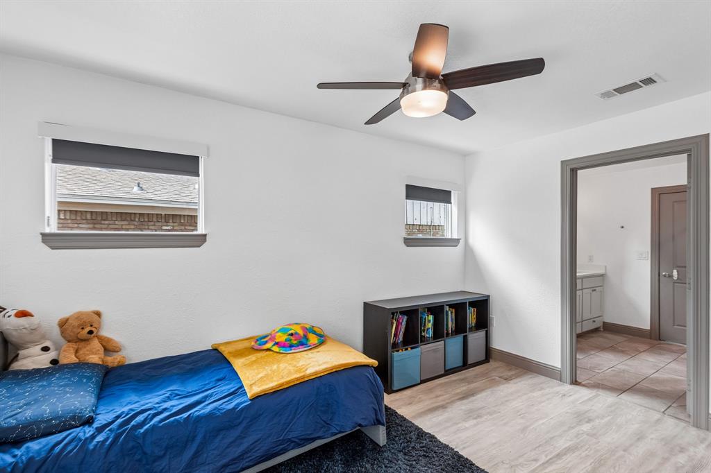 5216 Ashbrook Road Dallas, TX 75227 - Photo 24 of 28 Bright secondary bedroom with wood-finish flooring, ample natural light from dual windows, and ceiling fan with integrated lighting