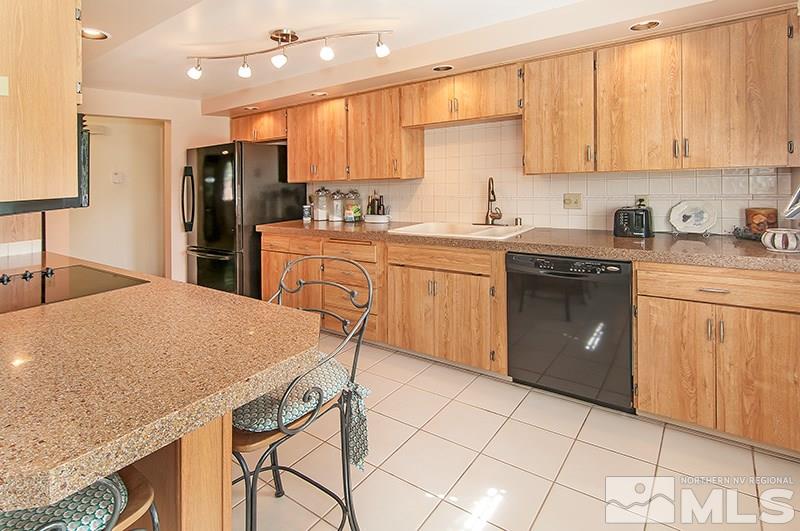 2520 Trentham Way Reno, NV 89509 - Photo 8 of 16 a kitchen with a sink a stove cabinets dining table and chairs