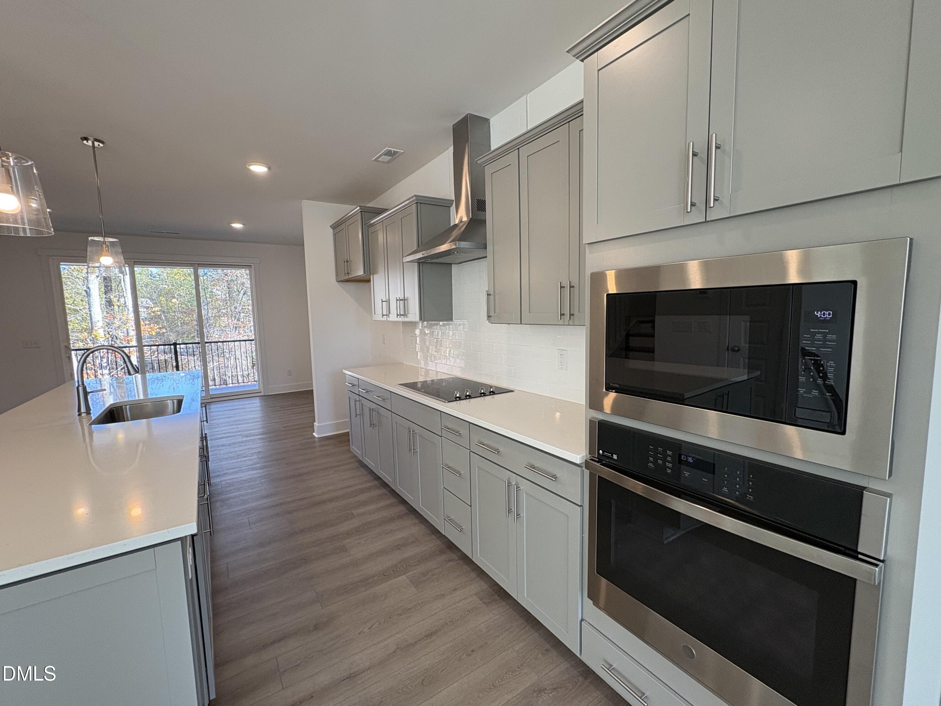 6046 Dunzo Drive Raleigh, NC 27617 - Photo 3 of 44 a large kitchen with stainless steel appliances wooden floor and a large window
