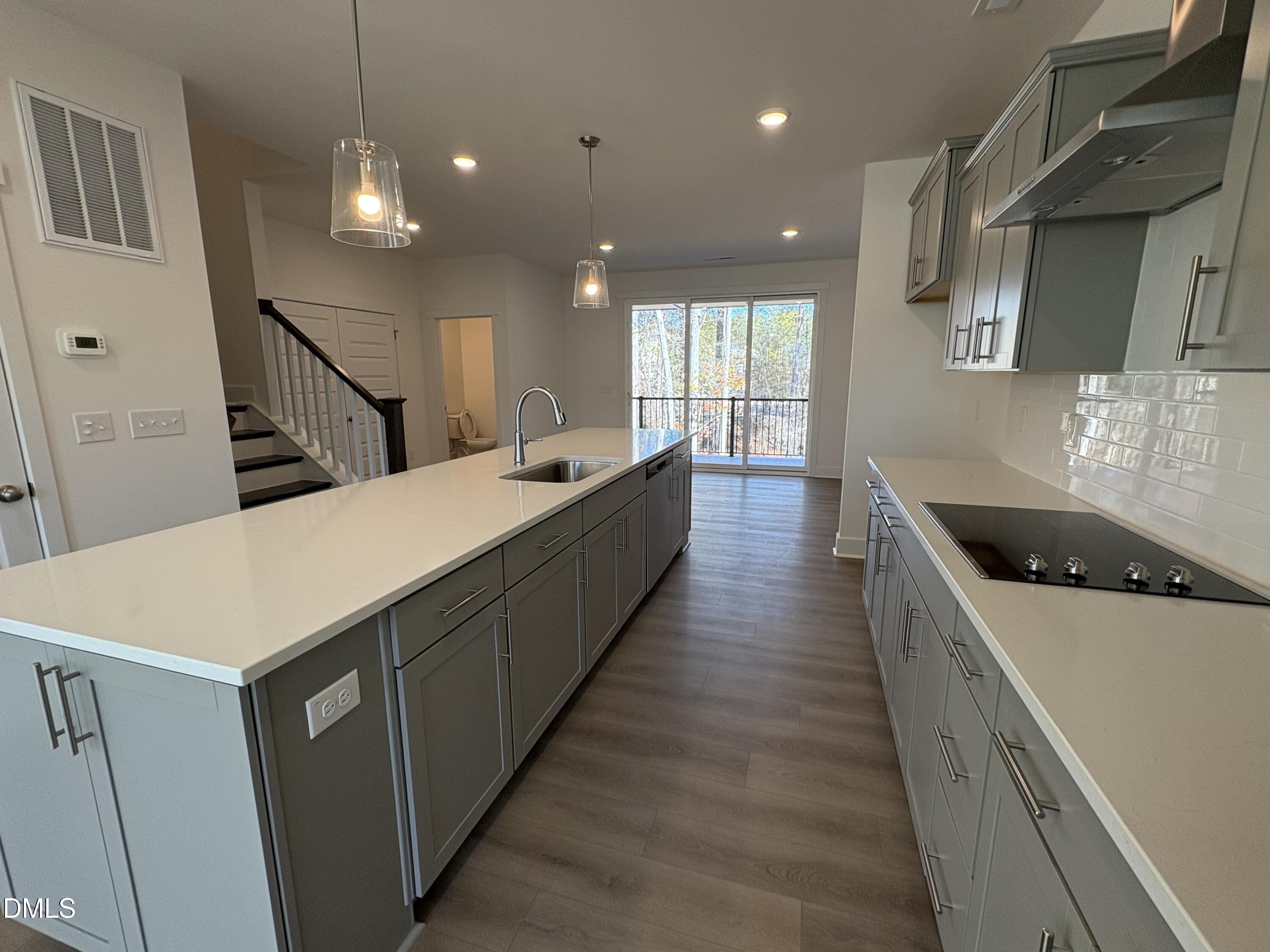 6046 Dunzo Drive Raleigh, NC 27617 - Photo 4 of 44 a large kitchen with stainless steel appliances a large counter top a refrigerator a sink and a stove
