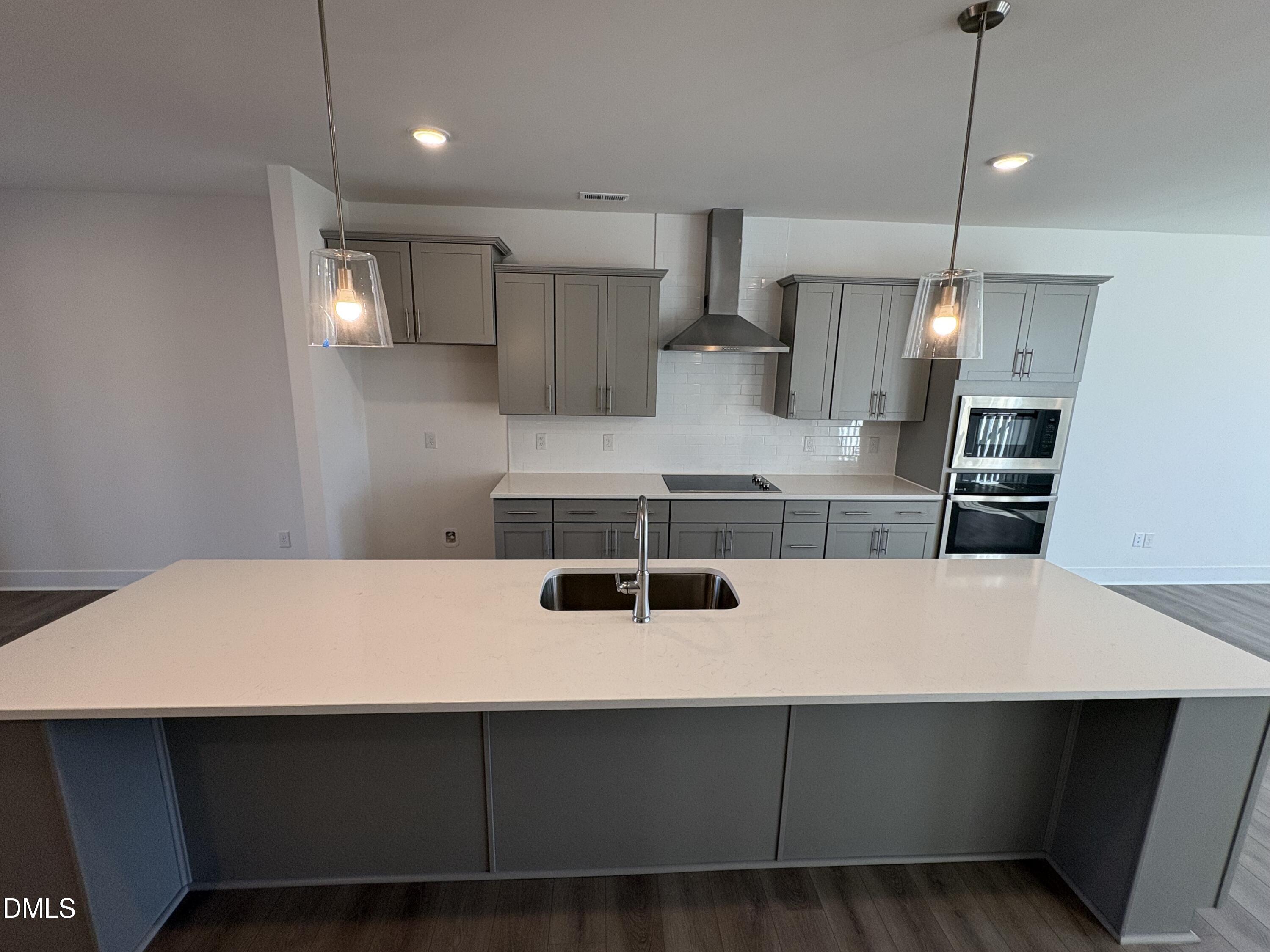 6046 Dunzo Drive Raleigh, NC 27617 - Photo 5 of 44 a kitchen with wooden cabinets a sink and a stove