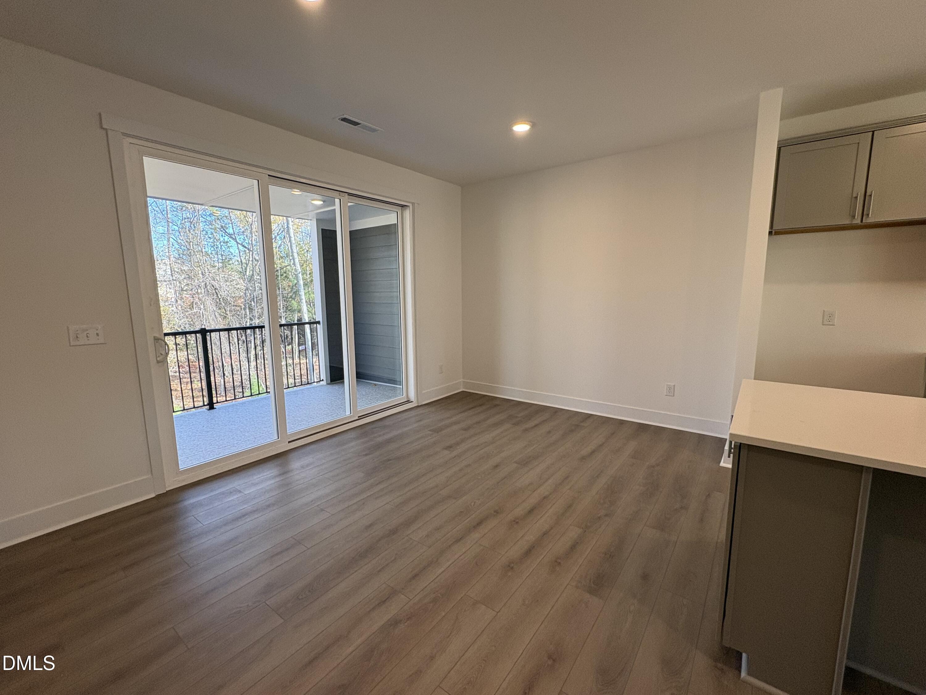 6046 Dunzo Drive Raleigh, NC 27617 - Photo 9 of 44 an empty room with wooden floor and windows