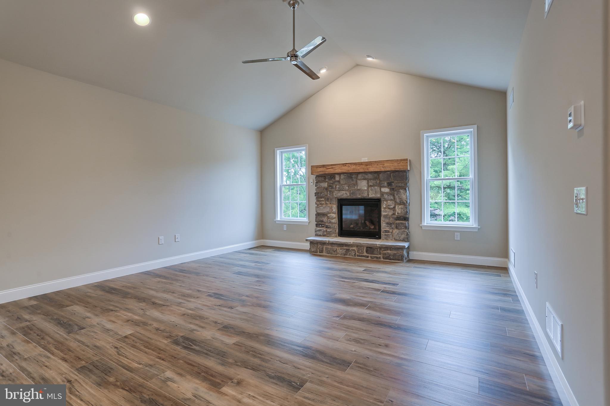 111 Starlight Lane Lebanon, PA 17046 - Photo 12 of 30 an empty room with wooden floor fireplace cabinet and windows