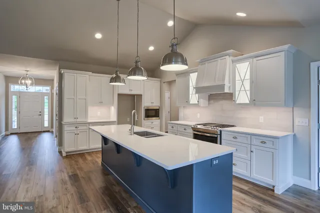 a kitchen with a sink a stove a refrigerator and cabinets