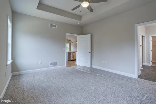 an empty room with a ceiling fan and a window