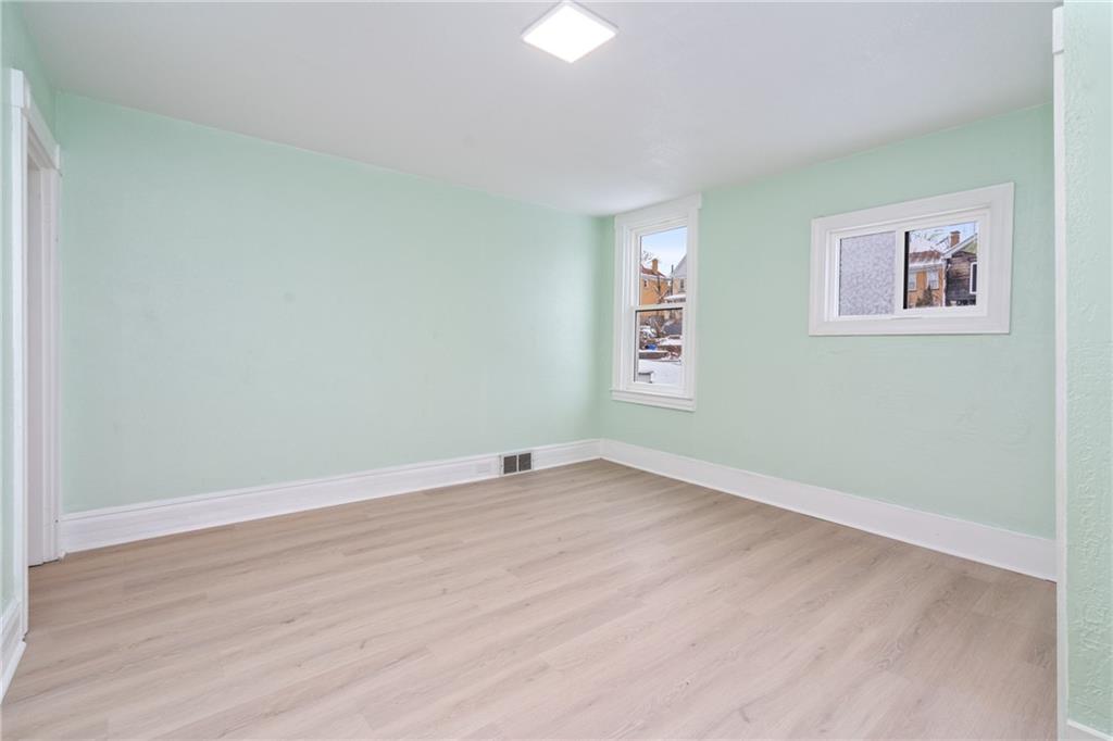 67 Ruth Street Pittsburgh, PA 15211 - Photo 19 of 26 an empty room with wooden floor and windows