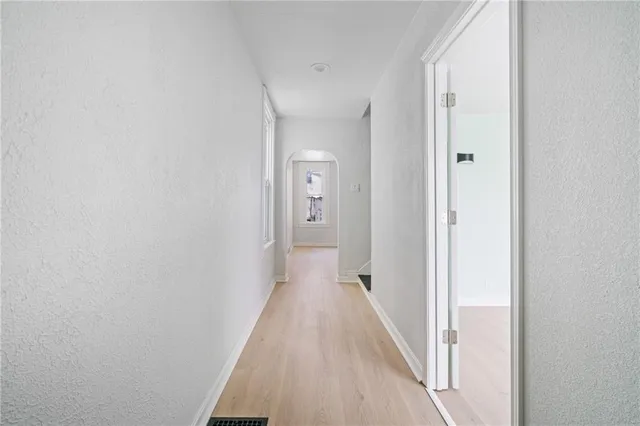 a view of a hallway with wooden floor
