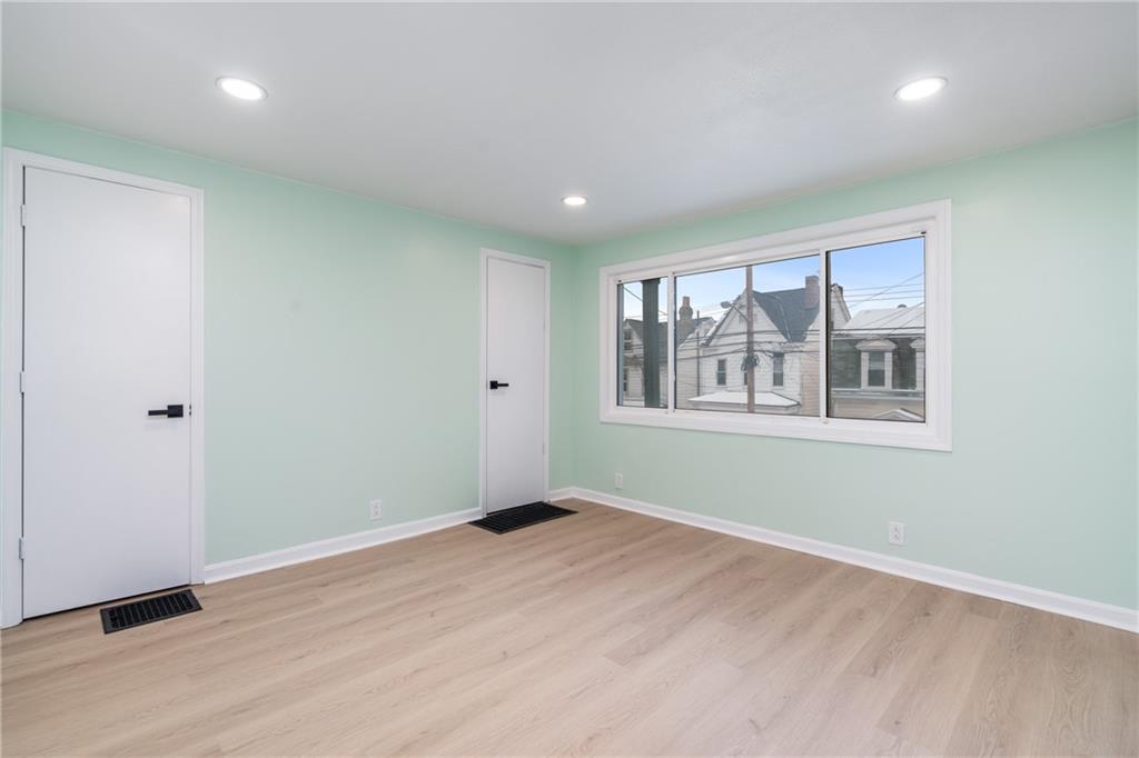 67 Ruth Street Pittsburgh, PA 15211 - Photo 5 of 26 a view of an empty room with a window and wooden floor