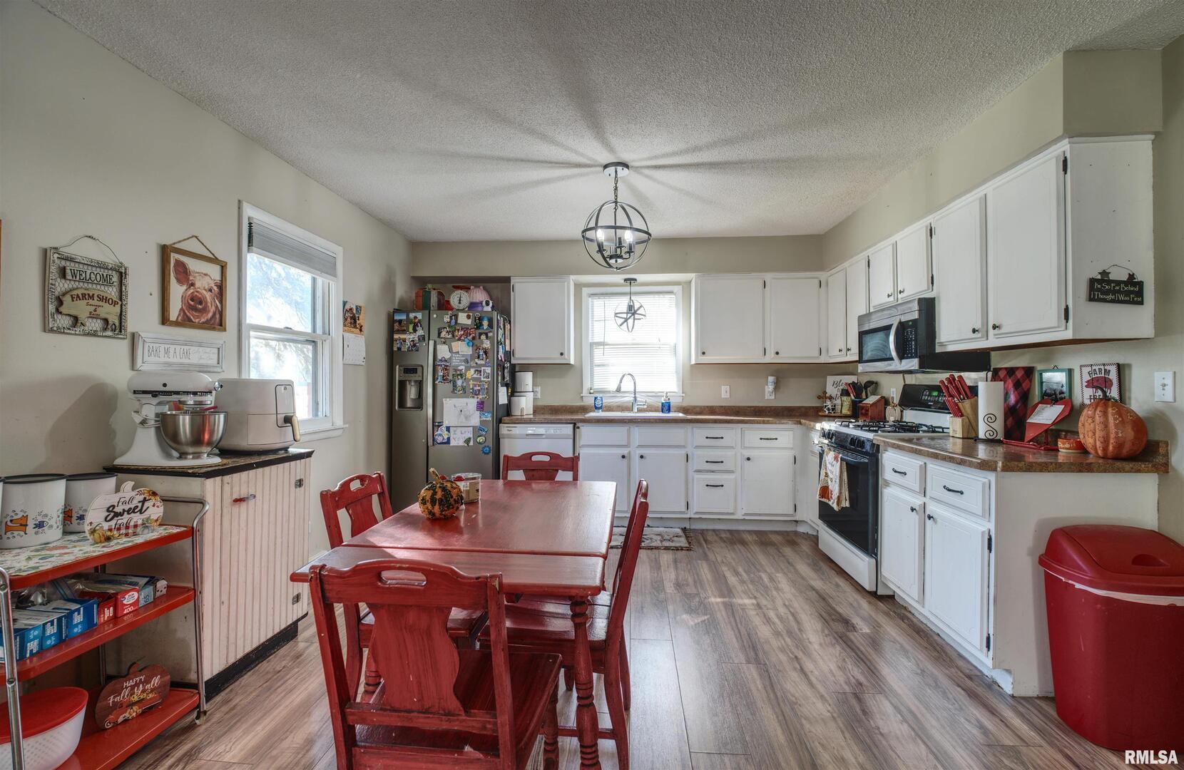 872 5th Avenue North Clinton, IA 52732 - Photo 6 of 19 a kitchen with a dining table chairs refrigerator and cabinets