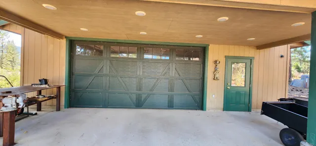 a view of a house with a yard tree and wooden fence