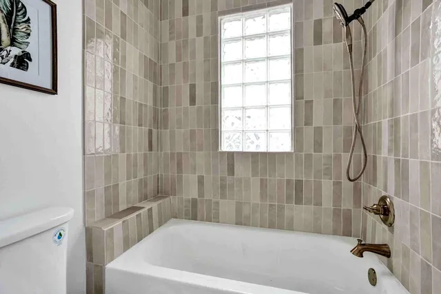 a bath tub sitting next to a white sink and a shower