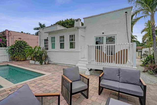 a view of a house with backyard and sitting area