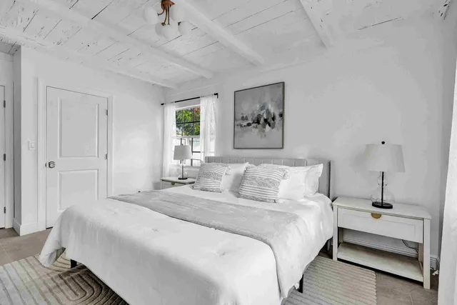 a bedroom with a bed and a painting on the wall