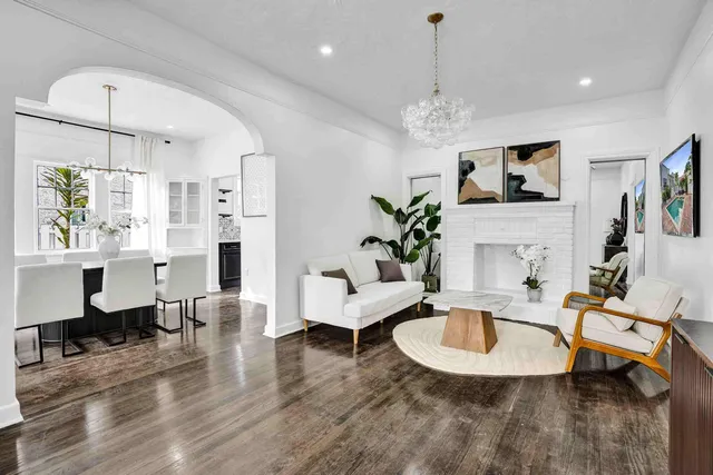 a living room with furniture chandelier and a flat screen tv