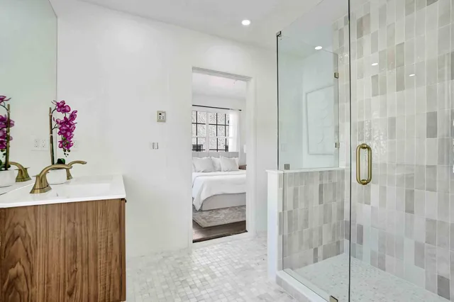 a en suite bathroom with a granite countertop sink mirror and shower