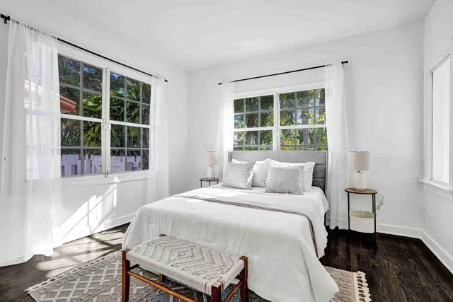a bedroom with a bed and a large window
