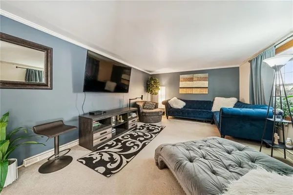 a living room with furniture a flat screen tv and a large window