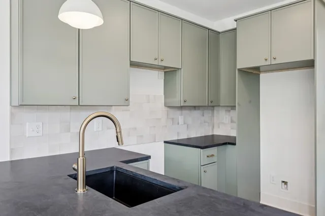 a kitchen with stainless steel appliances white cabinets a sink and a large window