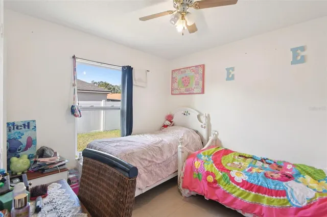 a bedroom with a bed that has a blanket and a painting on the wall