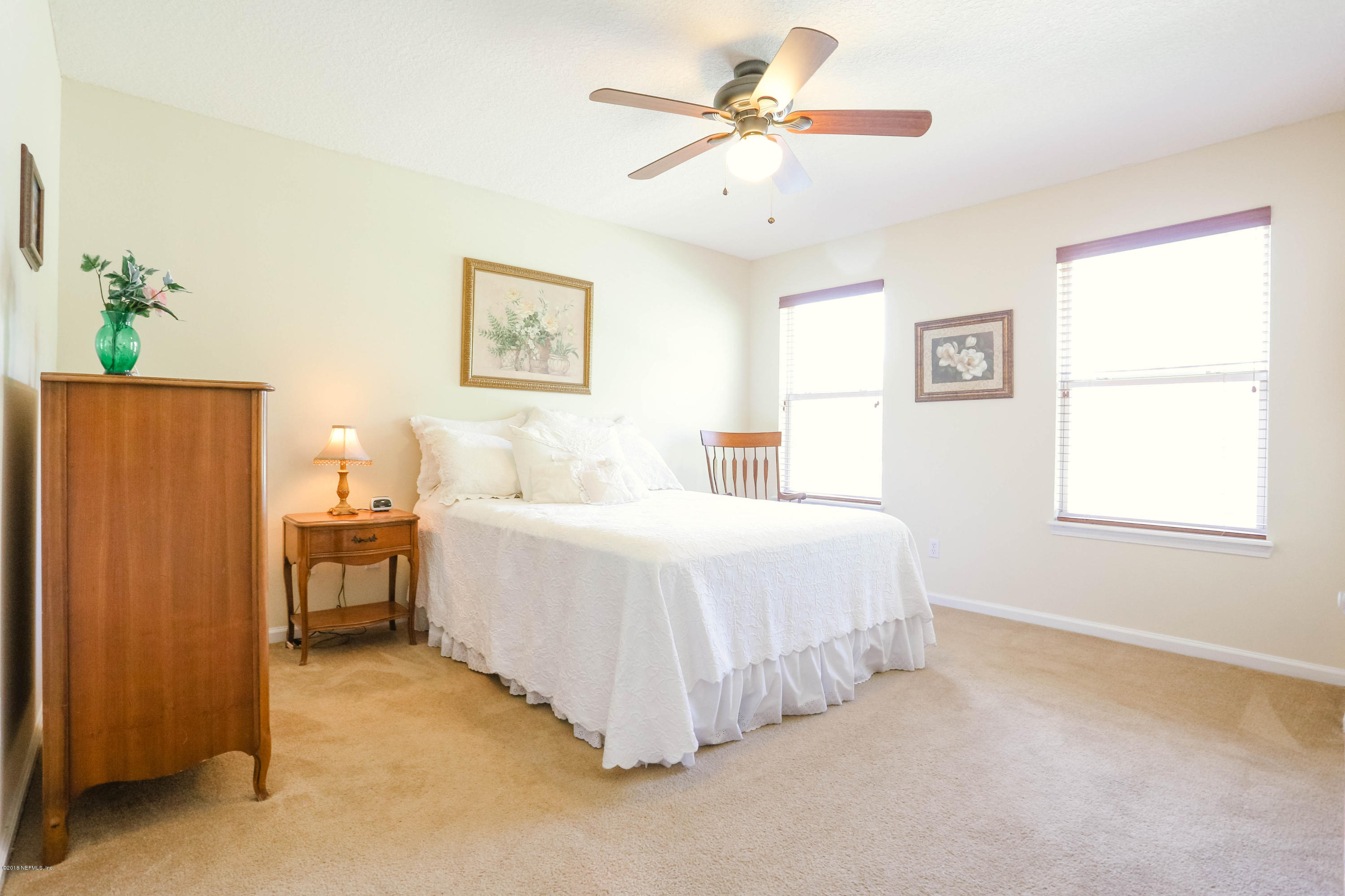 1205 Southern Stream Court Jacksonville, FL 32259 - Photo 20 of 42 a spacious bedroom with a bed and a chandelier
