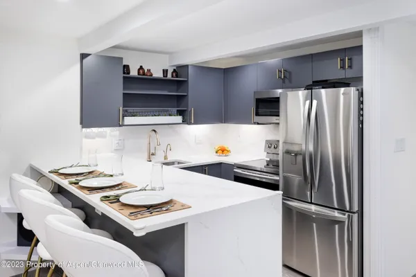 a kitchen with a refrigerator and a stove