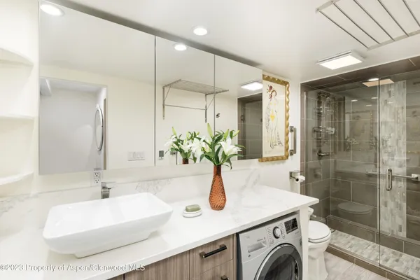 a bathroom with a sink a toilet and shower