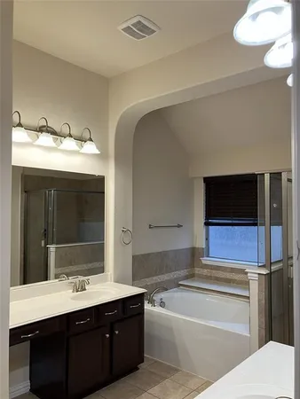 a bathroom with a tub sink and mirror