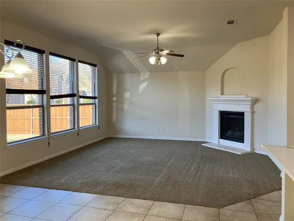 an empty room with windows and fireplace