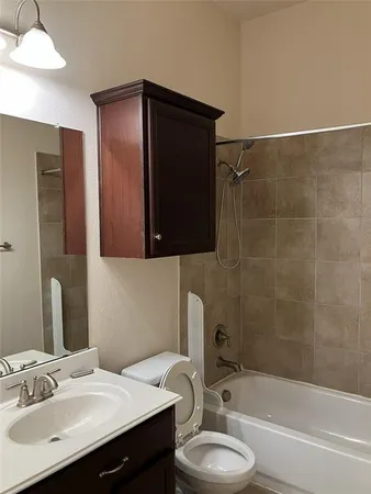 a bathroom with a sink toilet a mirror and bathtub