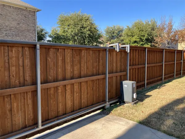 a view of a backyard with wooden fence
