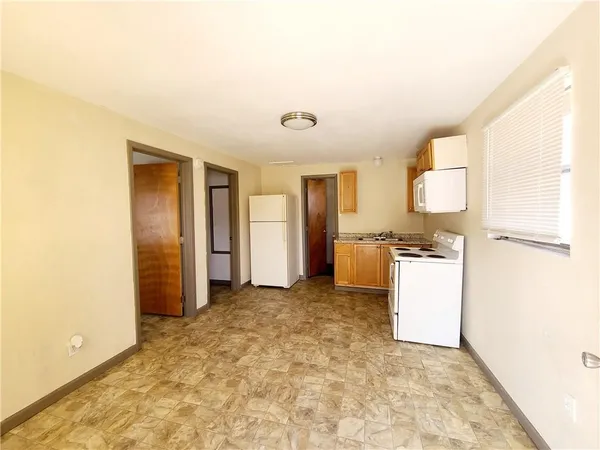 a view of a kitchen with a sink and a refrigerator