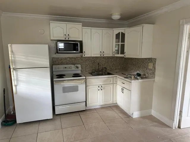 a kitchen with white cabinets and white appliances