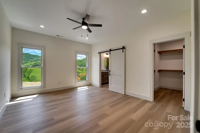 a view of empty room with wooden floor and window