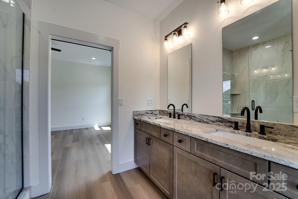 70 Knox Best Street Clyde, NC 28721 - Photo 21 of 33 a bathroom with a granite countertop sink a toilet and a mirror
