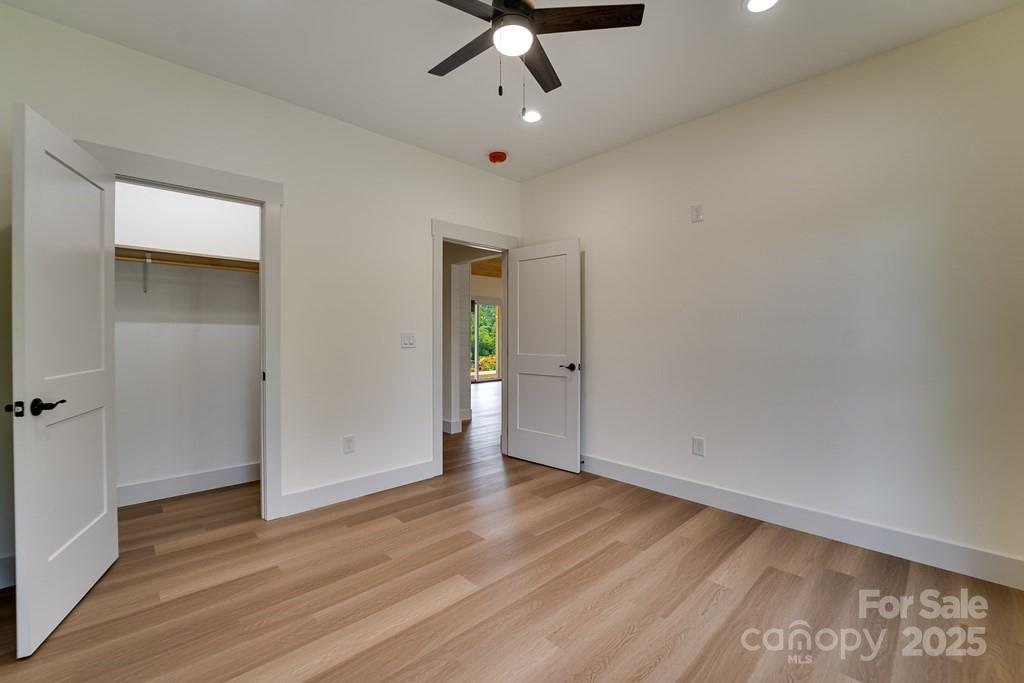 70 Knox Best Street Clyde, NC 28721 - Photo 24 of 33 an empty room with wooden floor cabinet and a ceiling fan