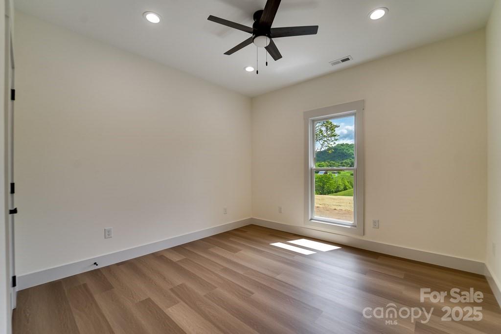 70 Knox Best Street Clyde, NC 28721 - Photo 26 of 33 wooden floor in an empty room with a window