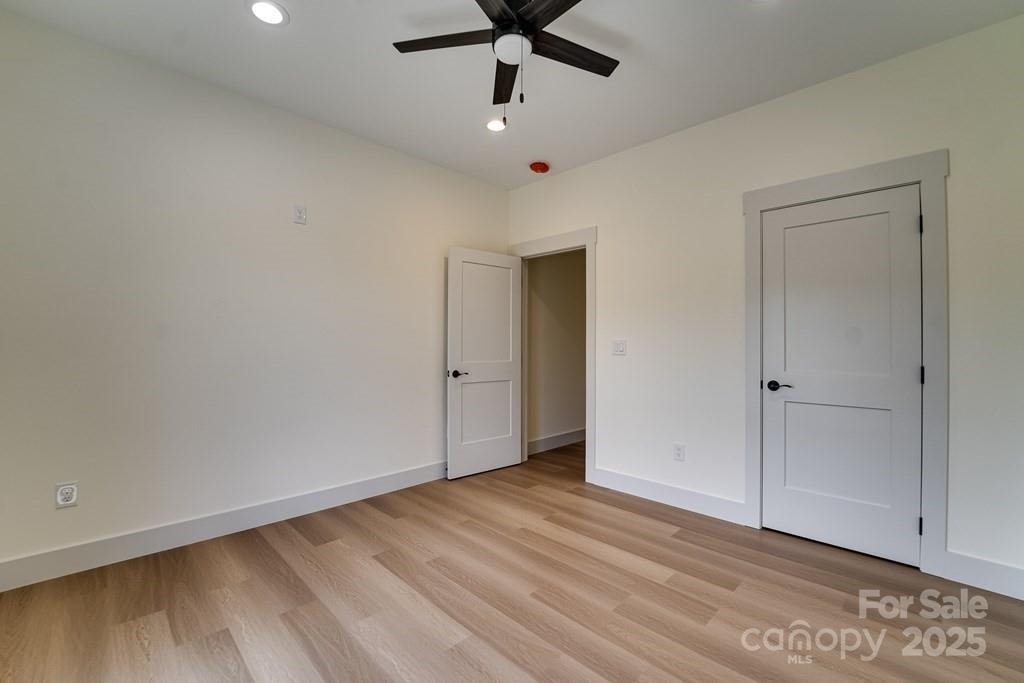 70 Knox Best Street Clyde, NC 28721 - Photo 27 of 33 a view of an empty room with wooden floor and a ceiling fan