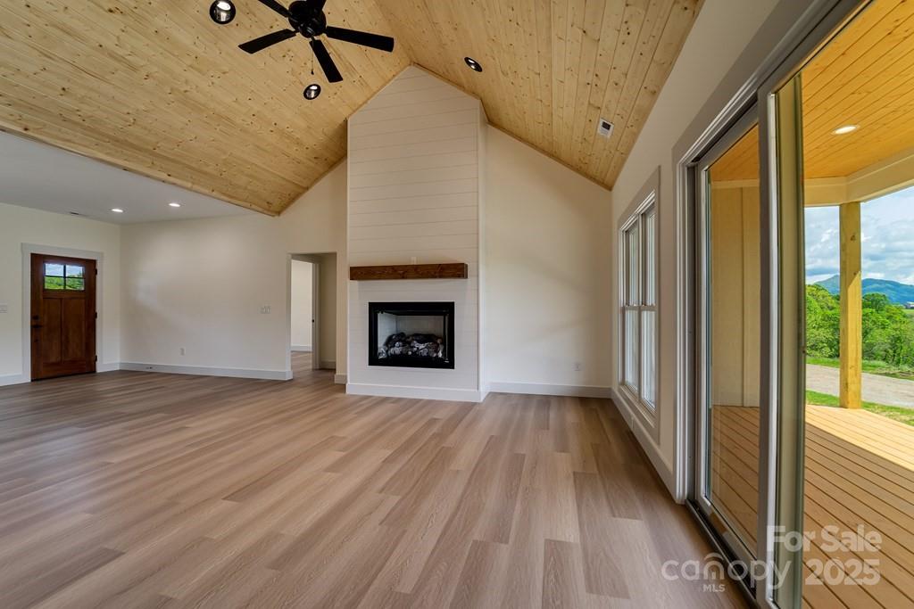 70 Knox Best Street Clyde, NC 28721 - Photo 6 of 33 a view of empty room with wooden floor and fireplace