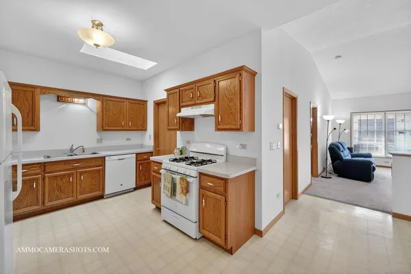 a kitchen with stainless steel appliances granite countertop a stove a refrigerator and a sink