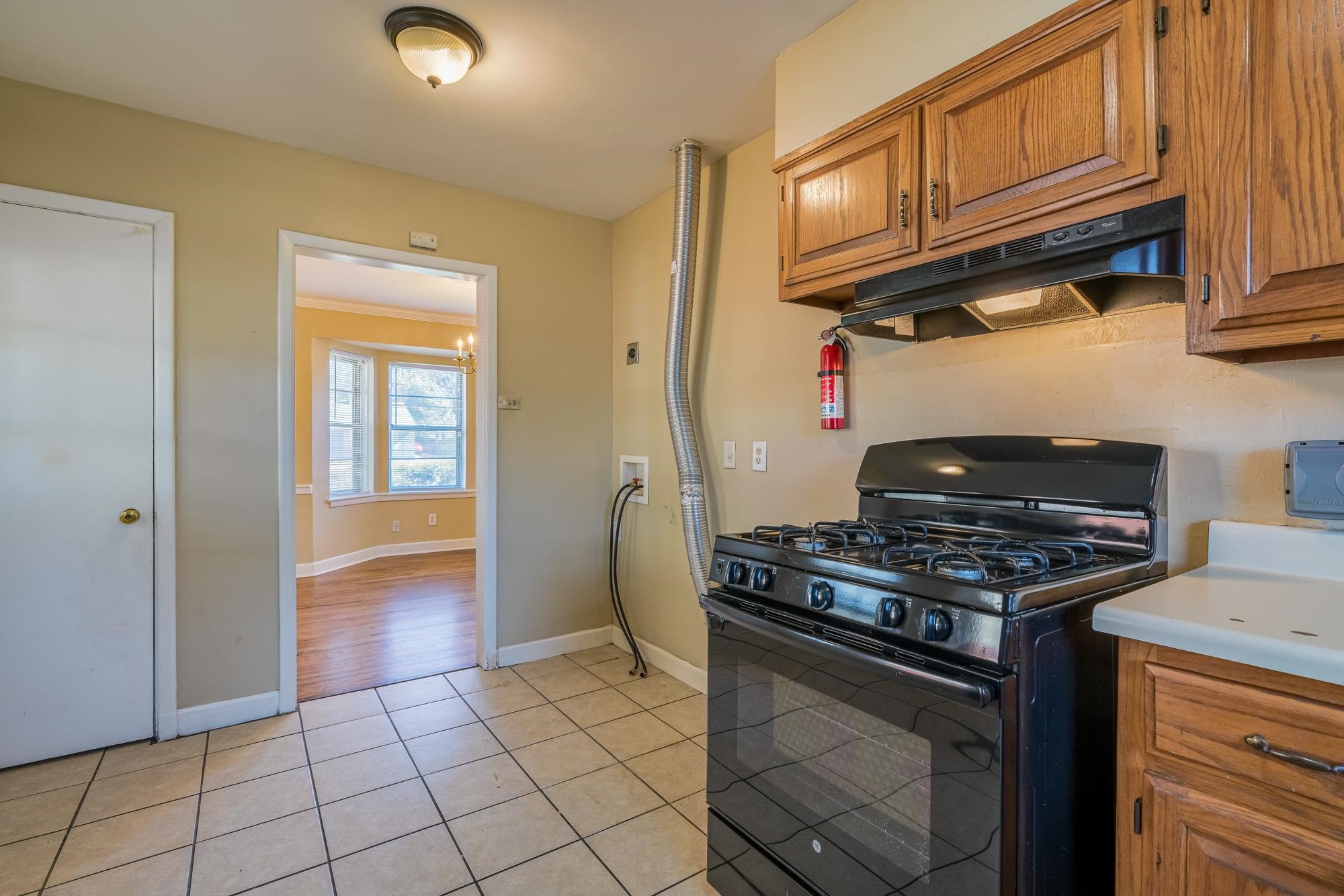 1117 South Perkins Road Memphis, TN 38117 - Photo 11 of 24 a kitchen with granite countertop a stove top oven cabinetry a chimney and cabinets